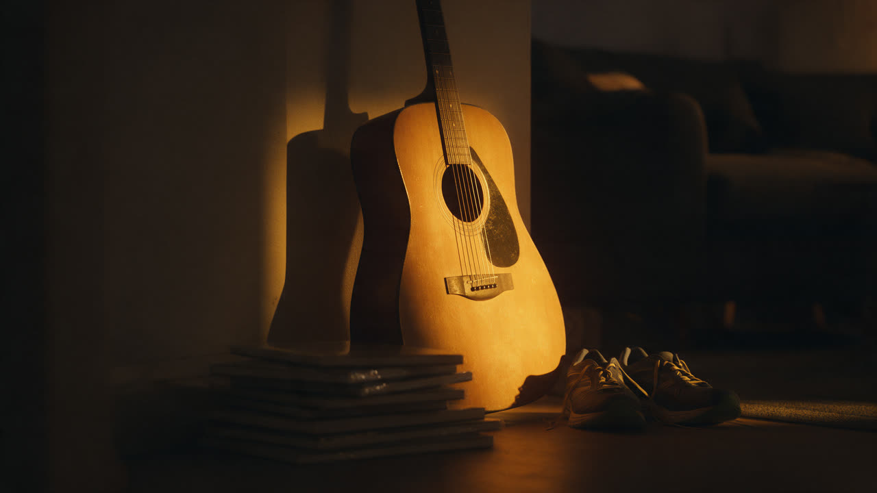 Verstaubte Gitarre in der Wohnzimmerecke, daneben unbenutzte Laufschuhe, nachts